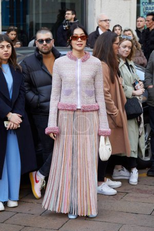 Téléchargez les photos : MILAN, ITALIE - 25 FÉVRIER 2023 : Femme avec longue, plissée, jupe et veste avec fermeture éclair avant le défilé de mode Missoni, Milan Fashion Week street style - en image libre de droit