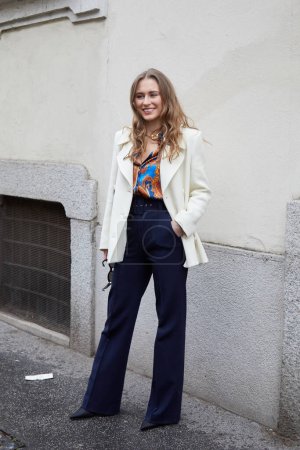 Téléchargez les photos : MILAN, ITALIE - 26 FÉVRIER 2023 : Femme avec pantalon bleu et veste blanche avant le défilé de mode Luisa Spagnoli, Milan Fashion Week street style - en image libre de droit