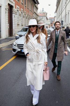 Téléchargez les photos : MILAN, ITALIE - 26 FÉVRIER 2023 : Femme avec manteau blanc et chapeau avant le défilé de mode Luisa Spagnoli, Milan Fashion Week street style - en image libre de droit