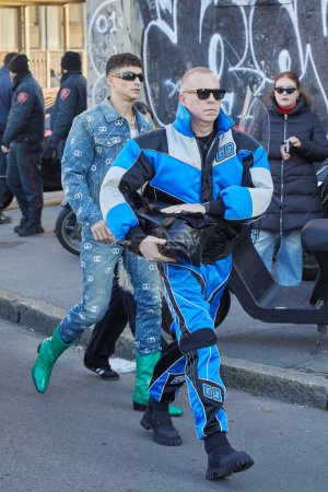 Foto de MILÁN, ITALIA - 12 DE ENERO DE 2024: Hombre con chaqueta deportiva Gucci azul, blanca y negra y pantalones antes del desfile de moda Gucci, Milan Fashion Week street styl - Imagen libre de derechos