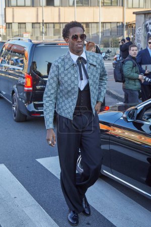 Téléchargez les photos : MILAN, ITALIE - 12 JANVIER 2024 : Homme veste grise avec logo Gucci et pantalon noir avant le défilé de mode Gucci, Milan Fashion Week street styl - en image libre de droit