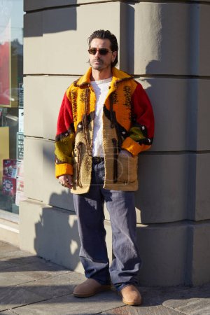 Photo for MILAN, ITALY - JANUARY 13, 2024: Giotto Calendoli with sunglasses and yellow and red ethnic jacket before MSGM fashion show, Milan Fashion Week street style - Royalty Free Image