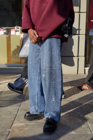 Foto de MILÁN, ITALIA - 13 DE ENERO DE 2024: Hombre con pantalones vaqueros azules de gran tamaño con pequeños patrones metálicos antes del desfile de moda MSGM, Milan Fashion Week street style - Imagen libre de derechos