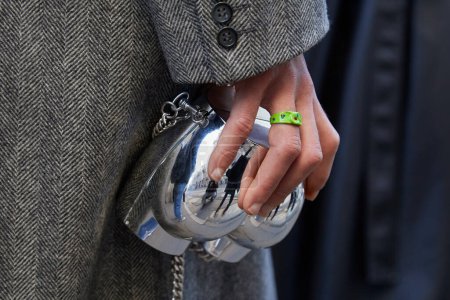 Téléchargez les photos : MILAN, ITALIE - 13 JANVIER 2024 : Homme avec sac arrière en argent et anneau en plastique vert avant le défilé Dolce et Gabbana, Milan Fashion Week street style - en image libre de droit