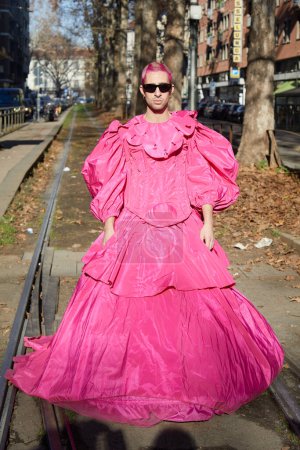Téléchargez les photos : MILAN, ITALIE - 13 JANVIER 2024 : Homme avec robe rose et cheveux avant le défilé Dolce et Gabbana, Milan Fashion Week street style - en image libre de droit