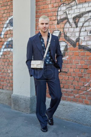 Téléchargez les photos : MILAN, ITALIE - 13 JANVIER 2024 : Homme avec un sac Fendi beige et une veste et un pantalon bleus avant le défilé Fendi, Milan Fashion Week street style - en image libre de droit