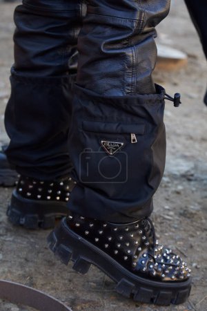 Foto de MILÁN, ITALIA - 13 DE ENERO DE 2024: Hombre con pantalones de cuero negro, zapatos con tacos y accesorios Prada antes del desfile de moda Fendi, Milan Fashion Week street style - Imagen libre de derechos