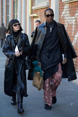 Téléchargez les photos : MILAN, ITALIE - 13 JANVIER 2024 : Femme avec trench-coat en cuir noir et homme avec chemise longue noire avant le défilé Fendi, Milan Fashion Week street style - en image libre de droit