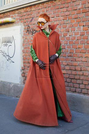 Téléchargez les photos : MILAN, ITALIE - 13 JANVIER 2024 : Femme avec chemise et pantalon en velours vert et manteau orange avant le défilé de mode Fendi, Milan Fashion Week street style - en image libre de droit