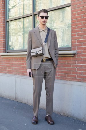 Photo for MILAN, ITALY - JANUARY 13, 2024: Man with beige Fendi bag and suit before Fendi fashion show, Milan Fashion Week street style - Royalty Free Image