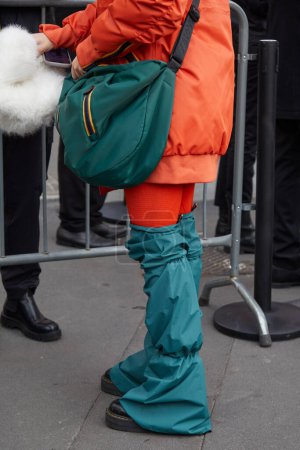 Téléchargez les photos : MILAN, ITALIE - 14 JANVIER 2024 : Femme avec sac K-way vert et veste orange avant le défilé K-Way, Milan Fashion Week street style - en image libre de droit