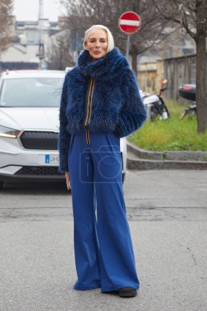 Téléchargez les photos : MILAN, ITALIE - 14 JANVIER 2024 : Femme avec un manteau et un pantalon en fourrure bleu K-way avant le défilé K-Way, Milan Fashion Week street style - en image libre de droit