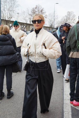Photo for MILAN, ITALY - JANUARY 14, 2024: Caroline Daur with white bomber jacket and black trousers before K-Way fashion show, Milan Fashion Week street style - Royalty Free Image