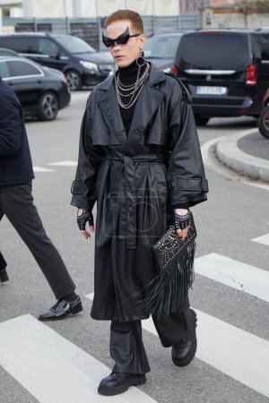 Foto de MILÁN, ITALIA - 14 DE ENERO DE 2024: Hombre con gabardina de cuero negro y pantalones antes del desfile de moda Prada, Milan Fashion Week street style - Imagen libre de derechos