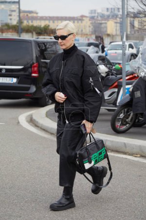 Téléchargez les photos : MILAN, ITALIE - 14 JANVIER 2024 : Femme avec veste bombardier noire et sac Prada avant le défilé de mode Prada, Milan Fashion Week street style - en image libre de droit