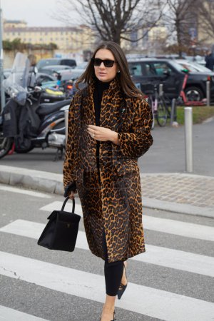 Téléchargez les photos : MILAN, ITALIE - 14 JANVIER 2024 : Femme avec un manteau à motif de peau de léopard avant le défilé Prada, Milan Fashion Week street style - en image libre de droit