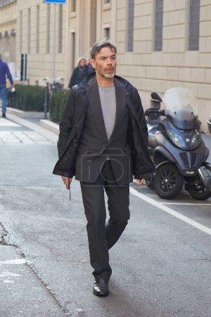 Photo for MILAN, ITALY - JANUARY 15, 2024: Man with grey jacket and trousers before Giorgio Armani fashion show, Milan Fashion Week street style - Royalty Free Image