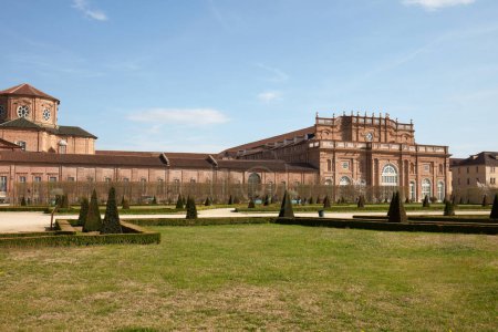 Foto de VENARIA REALE, ITALIA - 29 DE MARZO DE 2023: Reggia di Venaria castillo arquitectura y parque con setos piramidales a la luz del sol de primavera - Imagen libre de derechos