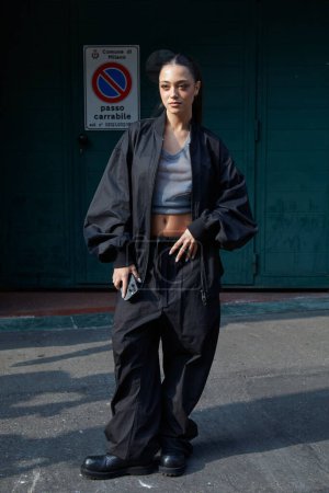 Photo for MILAN, ITALY - FEBRUARY 21 , 2024: Woman with black bomber jacket and trousers before Onitsuka Tiger fashion show, Milan Fashion Week street styl - Royalty Free Image