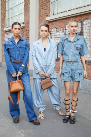 Photo for MILAN, ITALY - FEBRUARY 21 , 2024: Women with blue denim overalls and shirt and shorts before Fendi fashion show, Milan Fashion Week street style - Royalty Free Image