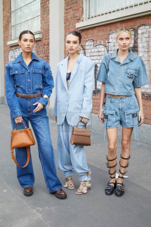 Photo for MILAN, ITALY - FEBRUARY 21 , 2024: Women with blue denim overalls and shirt and shorts before Fendi fashion show, Milan Fashion Week street style - Royalty Free Image