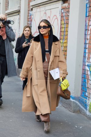 Téléchargez les photos : MILAN, ITALIE - 21 FÉVRIER 2024 : Femme avec manteau beige et pantalon marron avant le défilé de mode Fendi, Milan Fashion Week street style - en image libre de droit