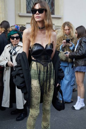Foto de MILÁN, ITALIA - 21 DE FEBRERO DE 2024: Mujer con corpiño negro y pantalones verdes transparentes con diseño floral antes del desfile de moda Marco Rambaldi, Milan Fashion Week street style - Imagen libre de derechos