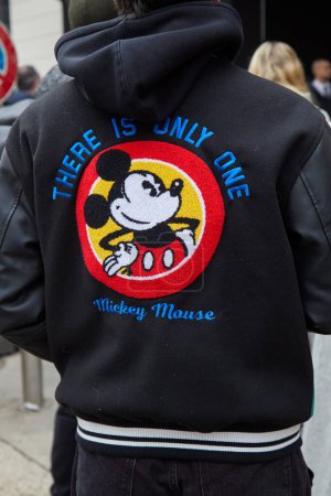 Photo for MILAN, ITALY - FEBRUARY 22 , 2024: Man with baseball bomber jacket with Mickey Mouse on back before Max Mara fashion show, Milan Fashion Week street style - Royalty Free Image