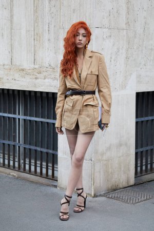 Téléchargez les photos : MILAN, ITALIE - 22 FEVRIER 2024 : Femme avec robe beige et cheveux roux avant le défilé Max Mara, Milan Fashion Week street style - en image libre de droit