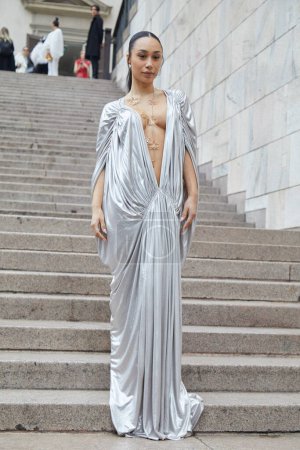 Téléchargez les photos : MILAN, ITALIE - 22 FÉVRIER 2024 : Femme avec une longue robe argentée avec décolleté plongeant et collier doré avant le défilé de mode Genny, Milan Fashion Week street style - en image libre de droit