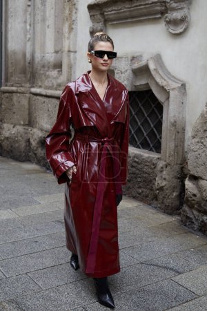 Téléchargez les photos : MILAN, ITALIE - 23 FÉVRIER 2024 : Femme avec un long trench-coat brillant avant le défilé de mode Blumarine, Milan Fashion Week street style - en image libre de droit
