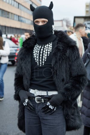 Téléchargez les photos : MILAN, ITALIE - 23 FÉVRIER 2024 : Homme avec cagoule noire et manteau de fourrure avant le défilé Gucci, Milan Fashion Week street style - en image libre de droit
