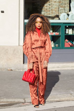 Foto de MILÁN, ITALIA - 24 DE FEBRERO DE 2024: Mujer con bolso rojo Ferrari y cuello alto antes del desfile de moda Ferrari, Milan Fashion Week street style - Imagen libre de derechos