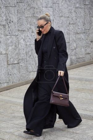 Photo for MILAN, ITALY - FEBRUARY 24 , 2024: Woman long, black coat and turtleneck before Ermanno Scervino fashion show, Milan Fashion Week street style - Royalty Free Image