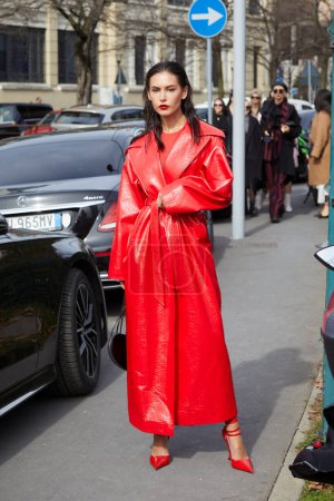 Téléchargez les photos : MILAN, ITALIE - 24 FÉVRIER 2024 : Femme avec un trench-coat en cuir rouge avant le défilé Ferragamo, Milan Fashion Week street style - en image libre de droit