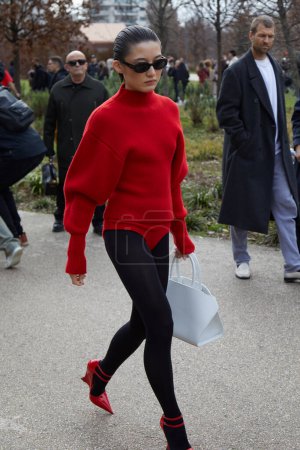 Foto de MILÁN, ITALIA - 24 DE FEBRERO DE 2024: Ashley Rous con suéter rojo y medias negras antes del desfile de moda Ferragamo, Milan Fashion Week street style - Imagen libre de derechos