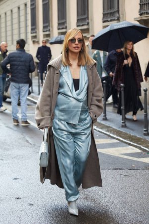 Foto de MILÁN, ITALIA - 25 DE FEBRERO DE 2024: Mujer con chaqueta de seda azul claro y pantalones antes del desfile de Giorgio Armani, Milan Fashion Week street style - Imagen libre de derechos
