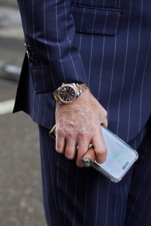 Foto de MILÁN, ITALIA - 25 DE FEBRERO DE 2024: Hombre con Rolex Datejust reloj y cigarro antes de Giorgio Armani desfile de moda, Milán Fashion Week street style - Imagen libre de derechos