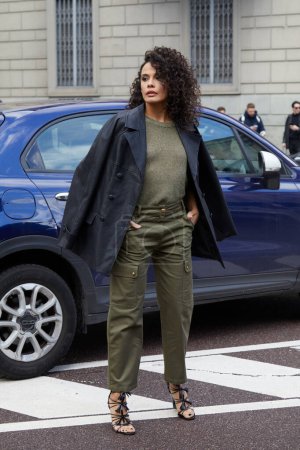 Téléchargez les photos : MILAN, ITALIE - 25 FÉVRIER 2024 : Femme avec pull vert olive et pantalon cargo avant le défilé de mode Luisa Spagnoli, Milan Fashion Week street style - en image libre de droit