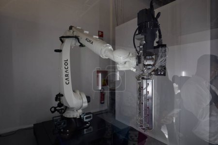 Foto de MILÁN, ITALIA - 17 DE ABRIL DE 2024: Impresión en 3D de caracol con brazo robótico Kuka trabajando durante la Semana del Diseño de Milán - Imagen libre de derechos