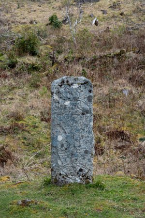 Photo for Pictish stone with distinct symbols carved on front face standing on ground, known to be a type of monumental stela, one of the less well-known historical landmarks located in Isle of Raasay, Scotland - Royalty Free Image