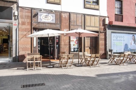 Photo for Cerveceria 100 Montaditos, La Laguna, Tenerife, Canary Islands, Spain - November 19, 2021: chairs and tables outside the popular Spanish restaurant chain specialized in tapas and bite-sized sandwiches - Royalty Free Image