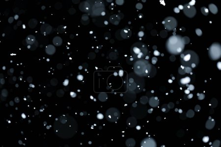 Téléchargez les photos : Bokeh flou de neige blanche tombant sur fond noir - en image libre de droit