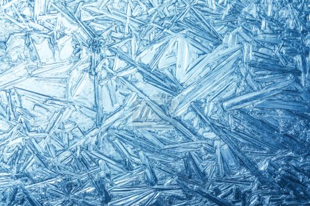 Téléchargez les photos : Fond hivernal avec fenêtre couverte de givre d'hiver avec un motif de cristaux de glace. - en image libre de droit