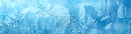 Téléchargez les photos : Fond hivernal avec fenêtre couverte de givre d'hiver avec un motif de cristaux de glace. - en image libre de droit