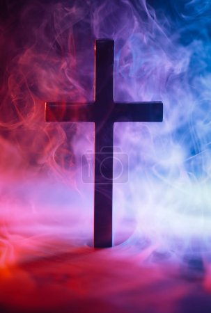 Foto de Cruz religiosa rodeada de humo rojo y azul que simboliza el Cielo y el Infierno, el bien y el mal, el bien y el mal, u otra metáfora de las elecciones morales. - Imagen libre de derechos