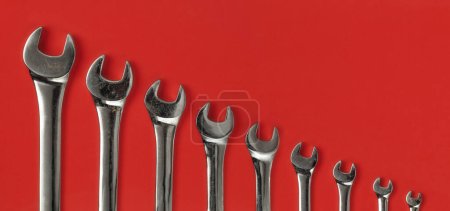Photo for Set of worn and used wrenches lined up on red background. - Royalty Free Image