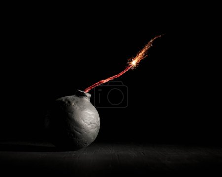 Photo for Round black bomb with lit fuse burning with sparks. Bomb about to detonate symbolizing destruction, threats, or dangerous violence. - Royalty Free Image