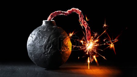 Téléchargez les photos : Bombe ronde noire avec fusible allumé brûlant avec des étincelles. Bombe sur le point de faire exploser symbolisant destruction, menaces ou violence dangereuse. - en image libre de droit