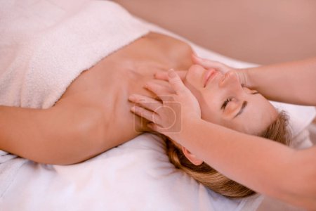 Photo for Woman getting face lifting massage in Spa Salon. Masseur making double chin treatment procedure to relaxed female lying with eyes closed - Royalty Free Image